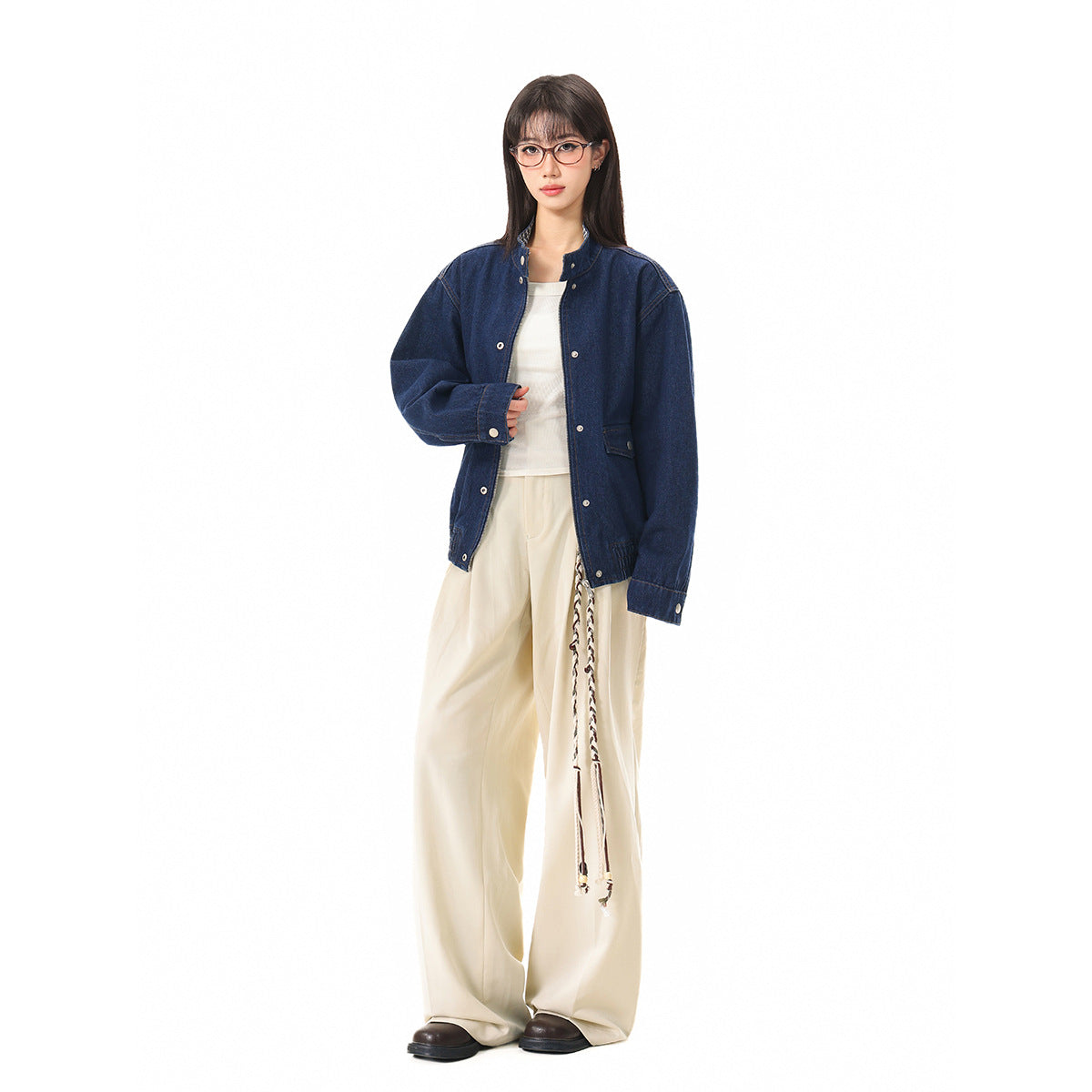 Full-length model wearing an oversized dark blue denim jacket with cream wide-leg trousers on a white background.