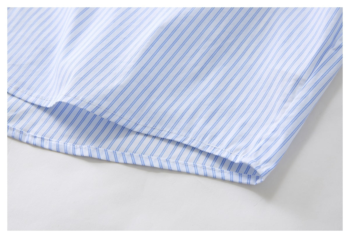 Close-up of the lower edge and side seam of a white shirt with fine blue stripes.