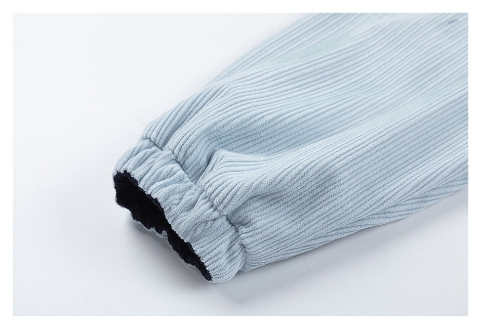 Close-up of a gathered elastic cuff on a light blue corduroy sleeve, with dark lining visible.