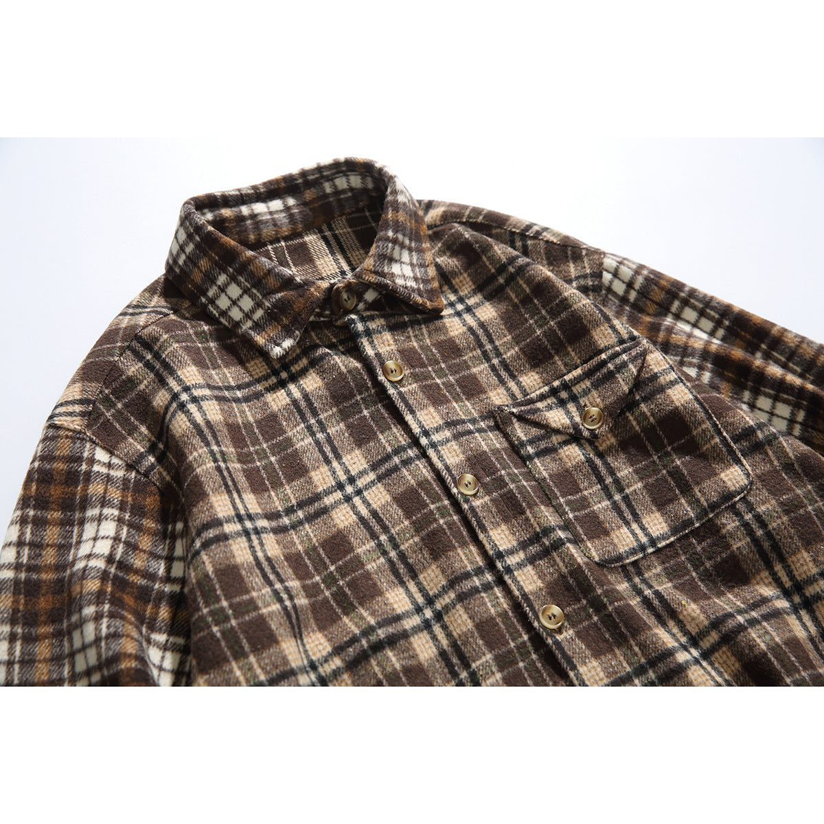 Close-up of a brown and cream plaid button-up shirt showing its collar, placket, and buttoned chest pocket.