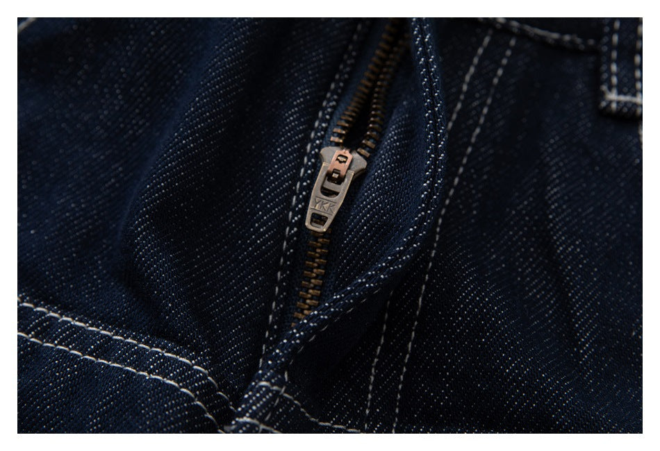 Close-up of dark indigo jeans showing a metal zipper and contrast-stitched seams.
