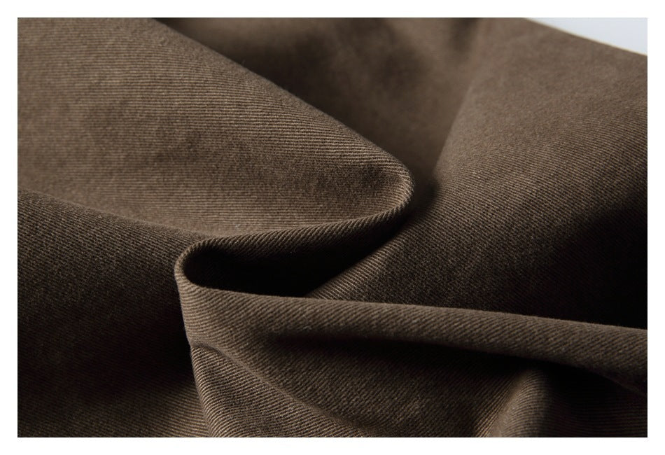 Macro view of brown fabric draped into folds, showing its fine diagonal weave.