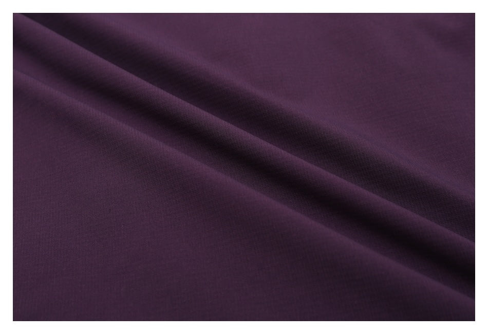 Close-up of deep plum-purple fabric with a diagonal fold and fine visible texture.