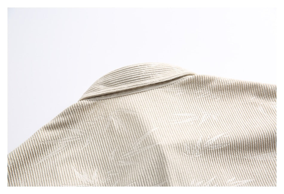 Close-up of the cream corduroy garment's collar and upper back, showing fine vertical ribs.