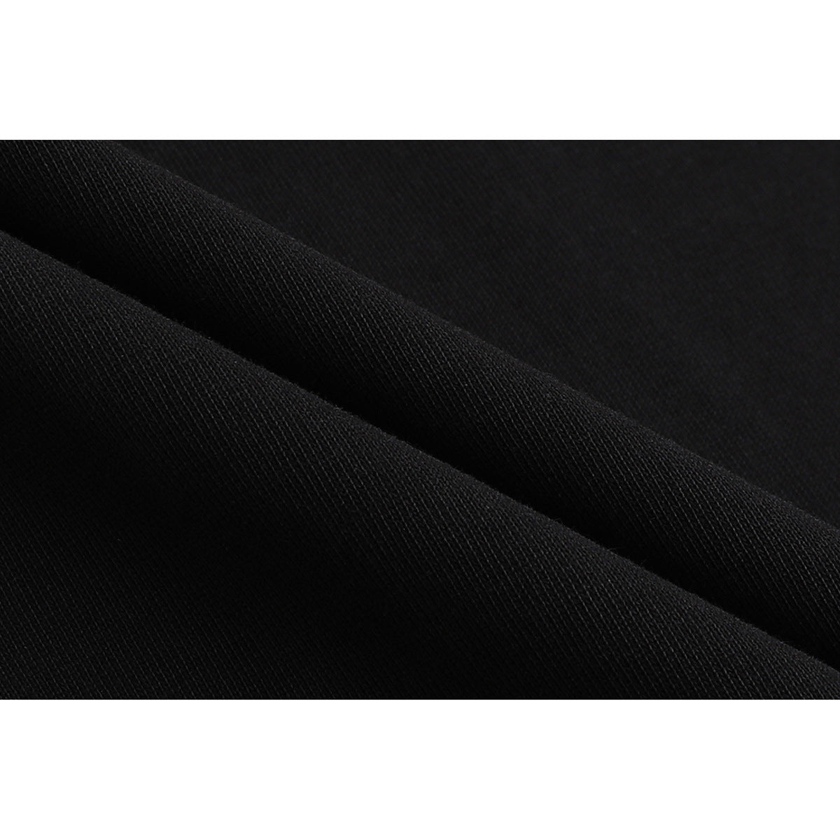 Extreme close-up of black fabric folded to show its fine ribbed texture.