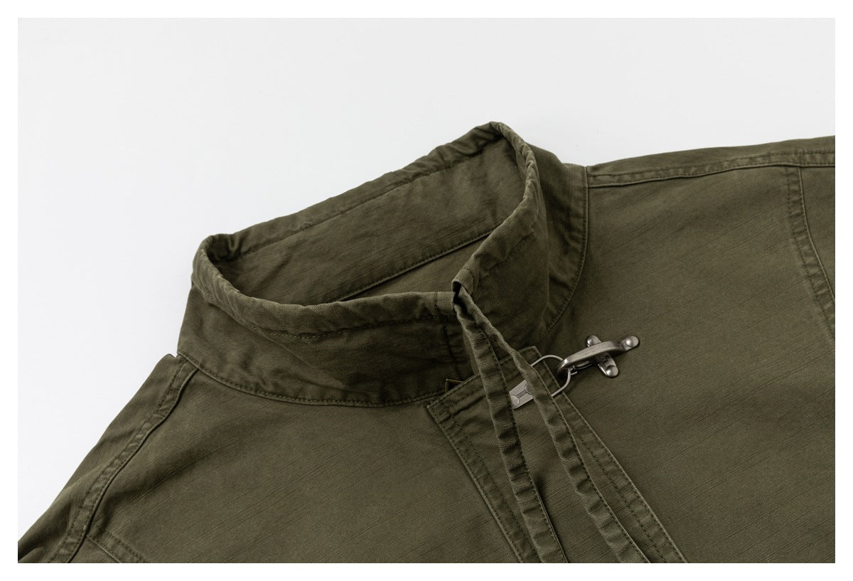 Close-up of the olive jacket's high collar, stitching and metal hook closure.
