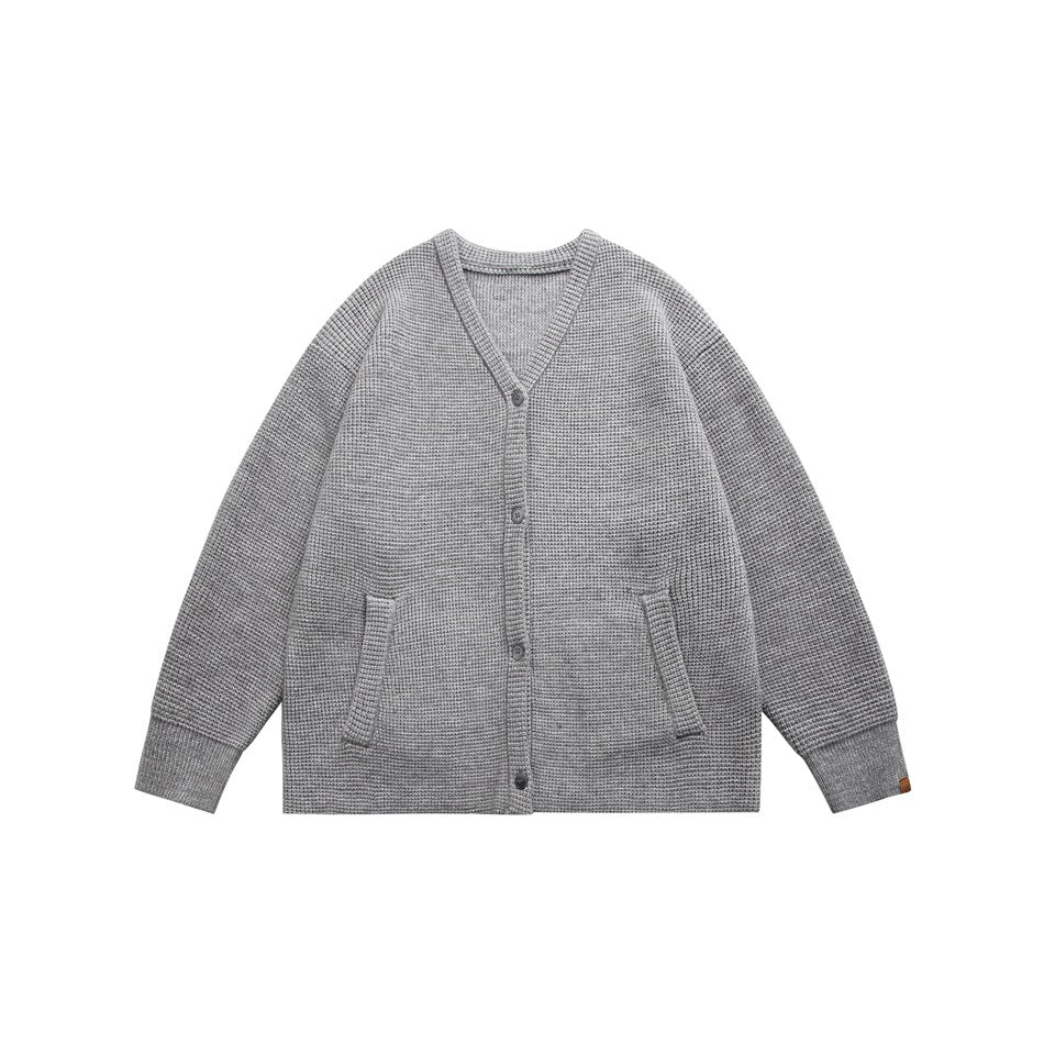 Light gray waffle-knit V-neck button cardigan with front pockets and ribbed cuffs, flat lay front view
