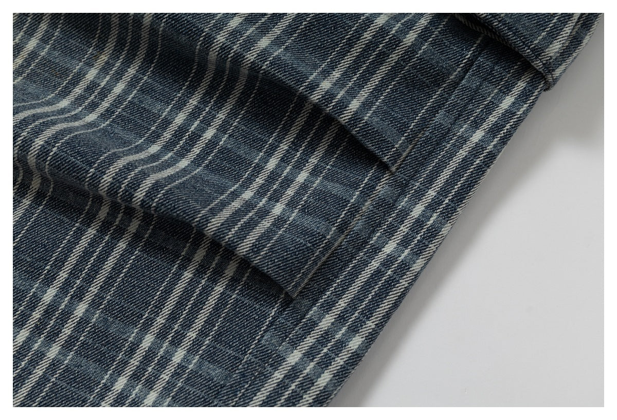 Close-up of dark blue and cream plaid fabric with a folded stitched seam.