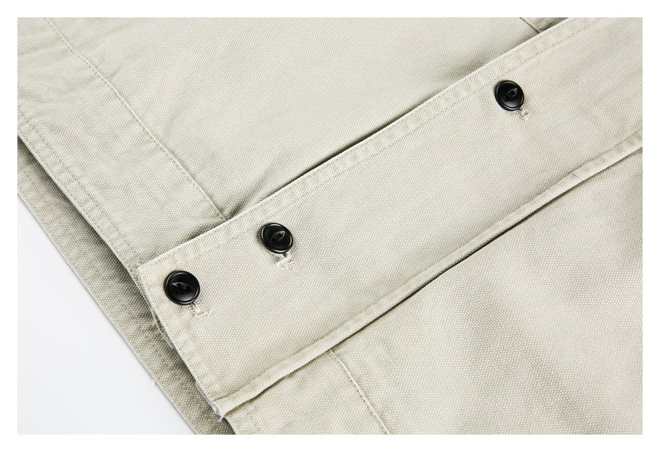 Close-up of a cream jacket's front placket with three black buttons and visible stitching.