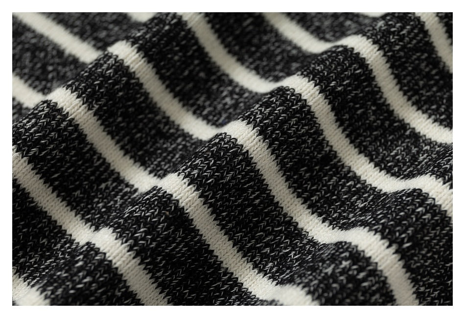 Macro view of the textured charcoal and cream striped knit fabric.