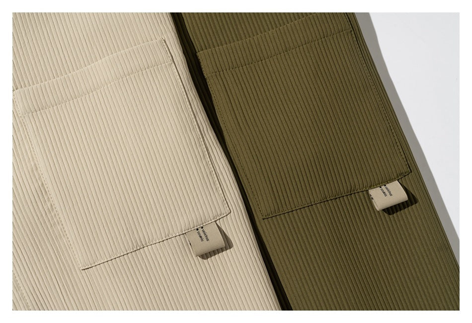Close-up of the ribbed fabric and large chest pockets on beige and olive green shirts.
