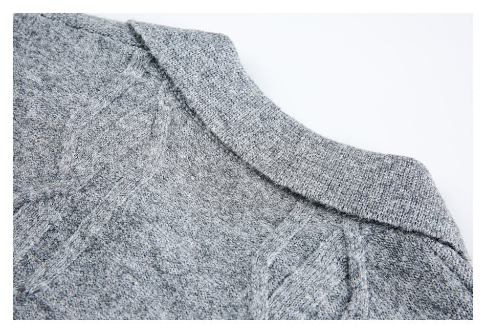 Close-up of a heather gray knitted garment's ribbed collar and shoulder seam.