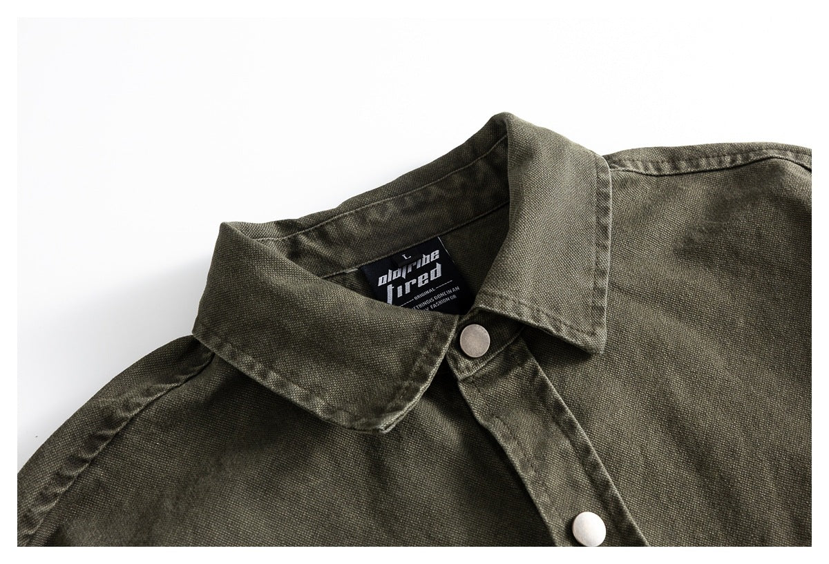 Close-up of an olive-gray shirt collar, metal snap buttons, and inner neck label.