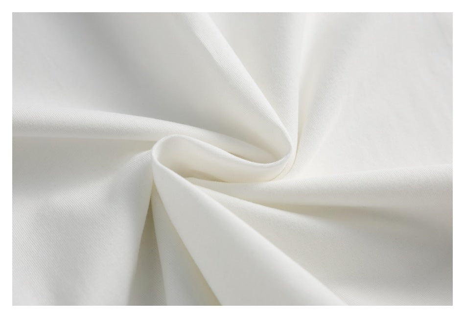 Close-up of white T-shirt fabric arranged in soft folds to show its surface texture.