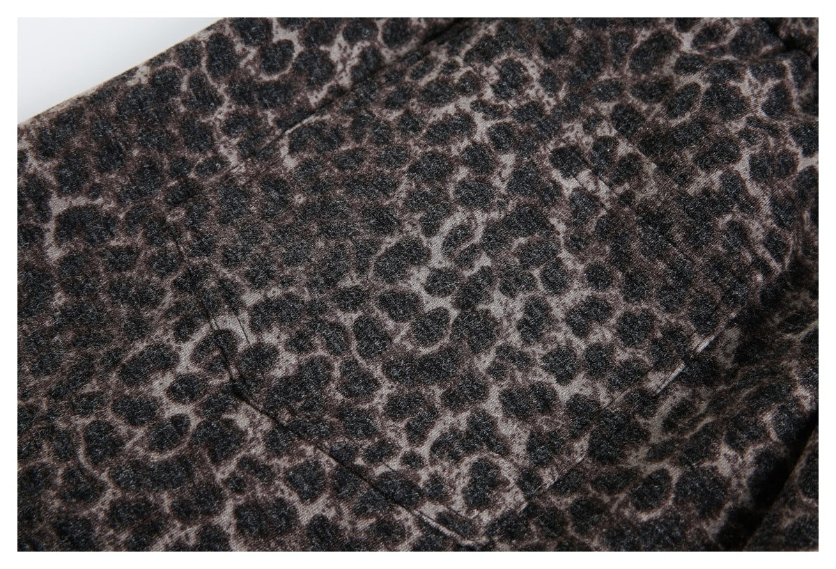 Close-up of a rectangular pocket stitched onto dark brown and black leopard-print fabric.