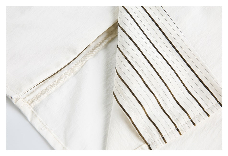Close-up of an ivory sleeve cuff with brown stripes and visible interior seam stitching.