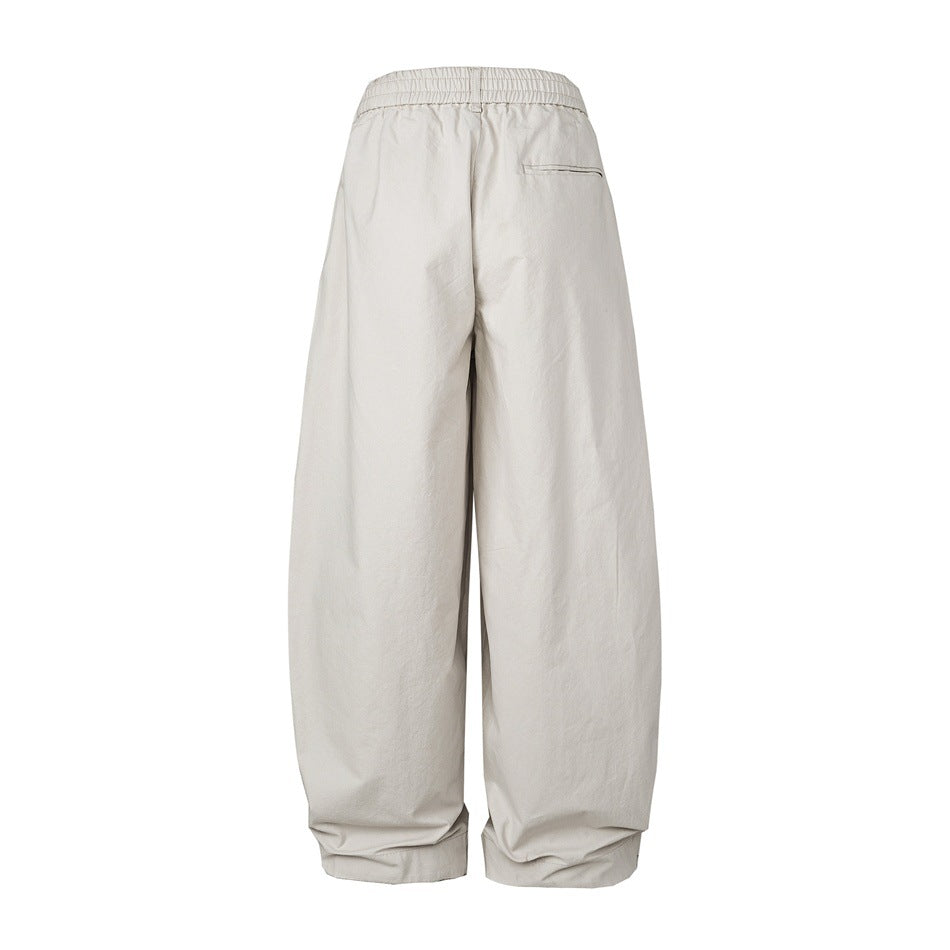 Back view of pale gray-beige wide-leg pants with an elasticated waistband and a single welt pocket.