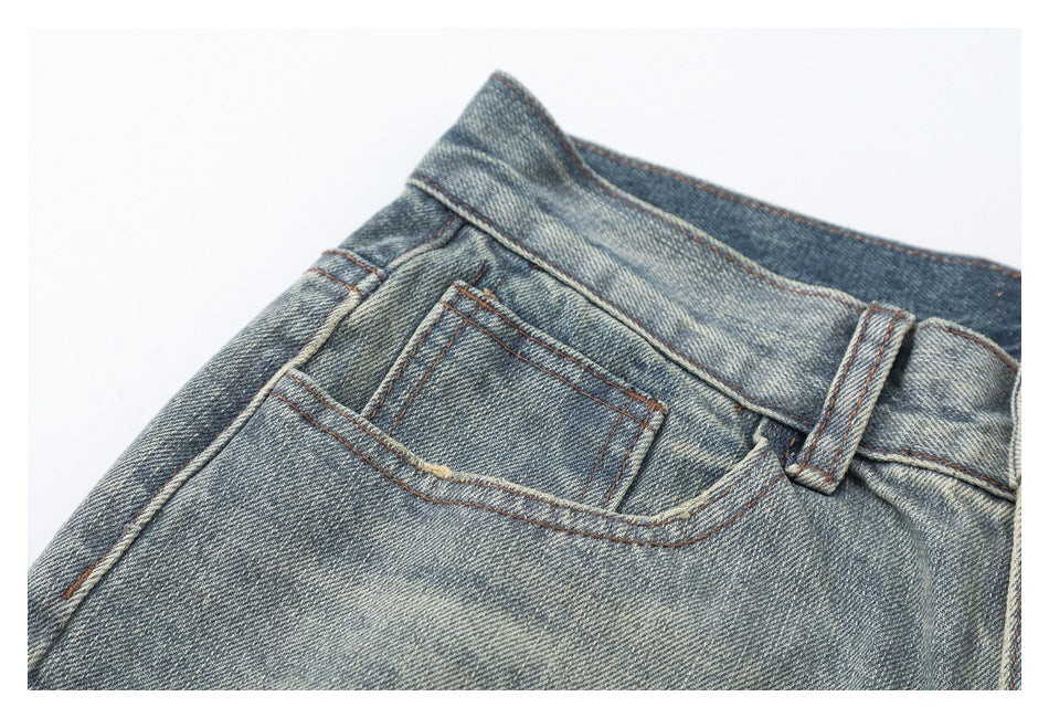 Close-up of the jeans' small front coin pocket, belt loop and contrasting brown stitching.