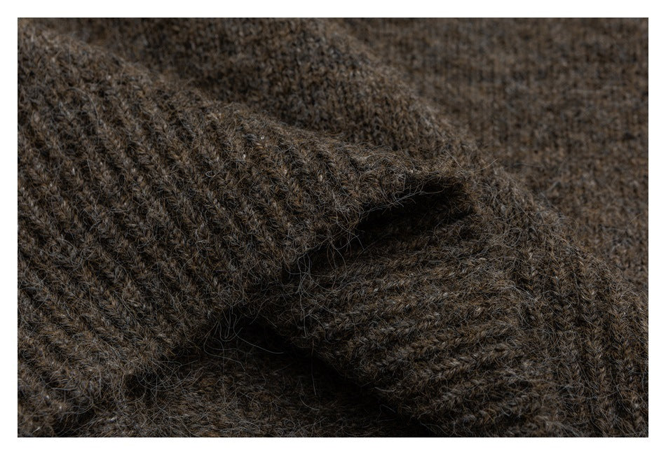 Close-up of dark brown fuzzy knit fabric with a thick folded edge and visible ribbed texture.