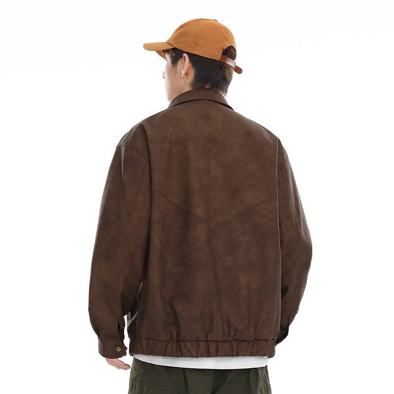 Rear view of a model wearing a brown jacket with curved back yoke seams, snap cuffs, and an elastic hem.