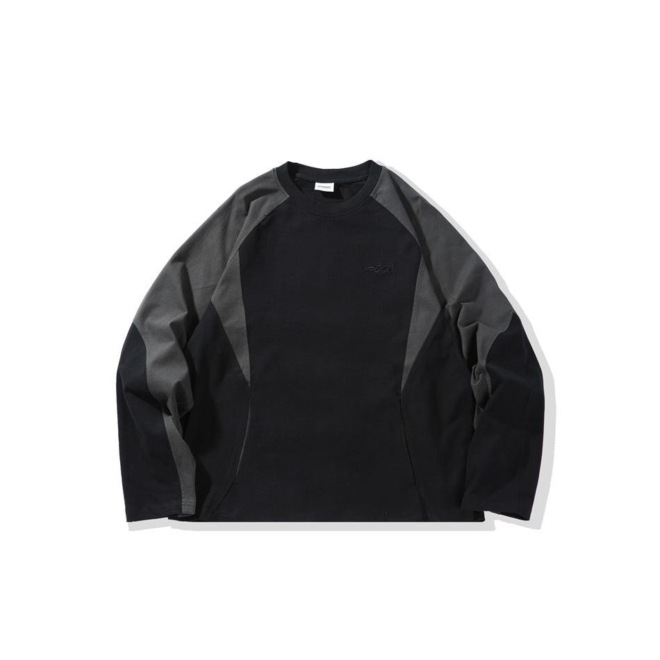 Black long-sleeve crew-neck top with charcoal gray raglan sleeve panels and small tonal chest embroidery, flat front view