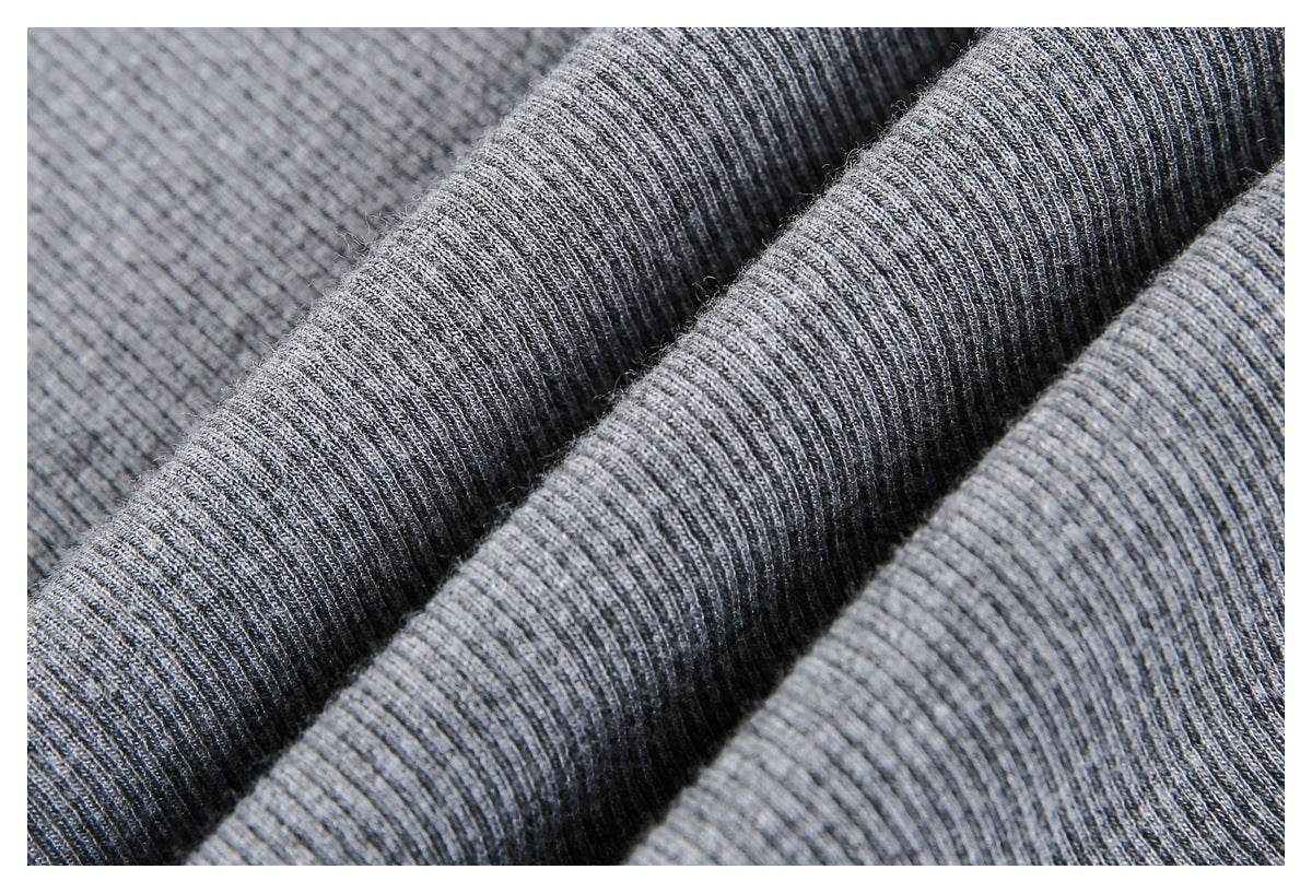 Macro view of heather-gray ribbed knit fabric gathered into folds, showing its texture.