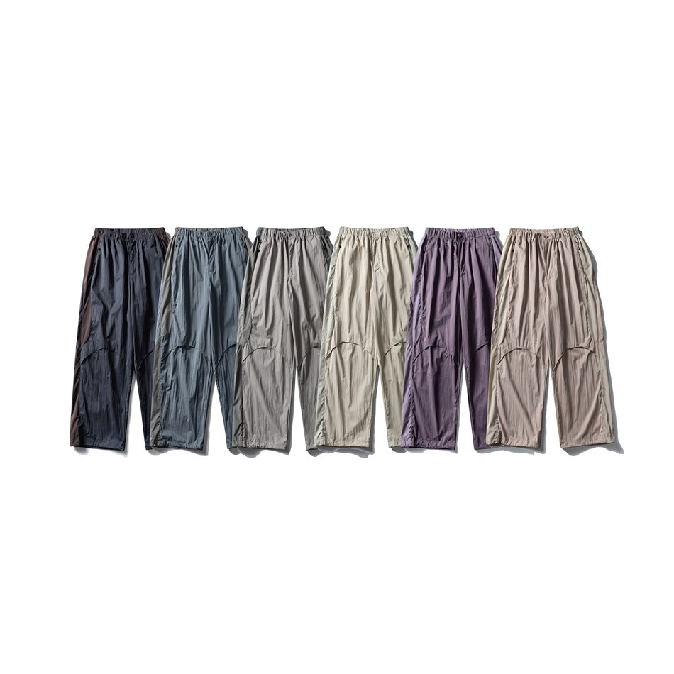 Six pairs of loose pants displayed side by side in dark, blue-gray, gray, cream, purple, and taupe colorways.