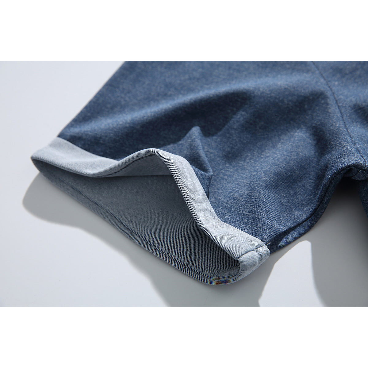 Close-up of the blue T-shirt's sleeve, showing its pale folded cuff and fabric texture.