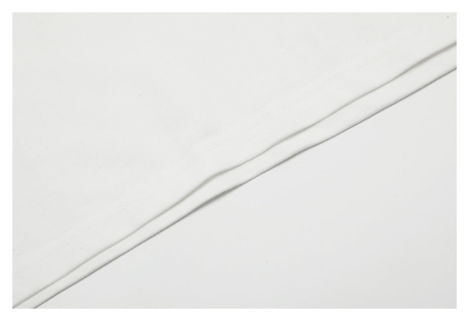 Close-up of a white garment's folded hem with visible stitching.