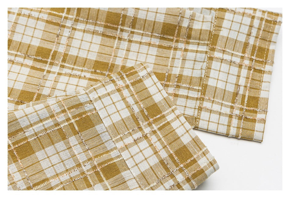 Close-up of the mustard-and-white plaid shirt sleeve and cuff.
