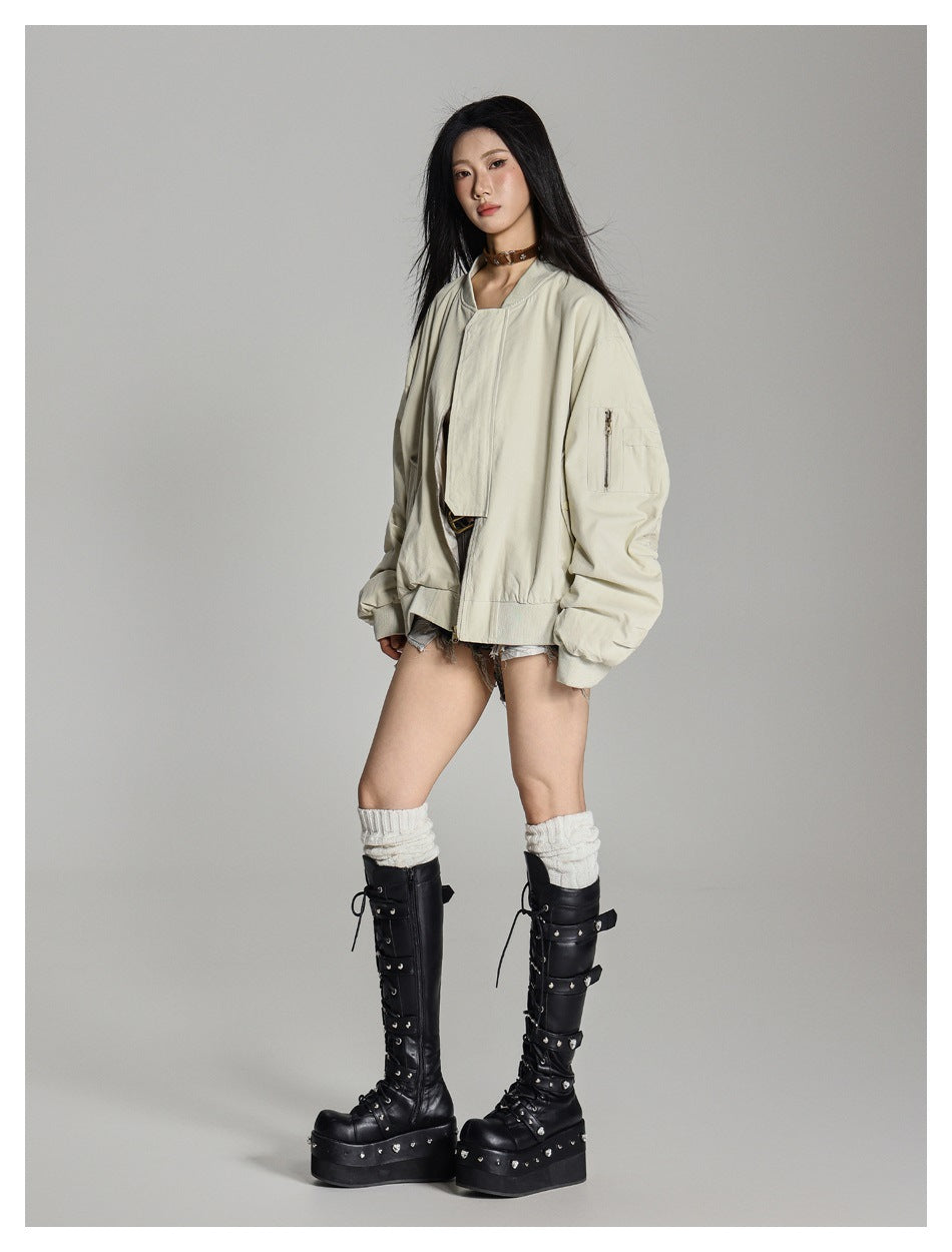 Full-length model wearing a pale beige oversized bomber jacket with a zip sleeve pocket.