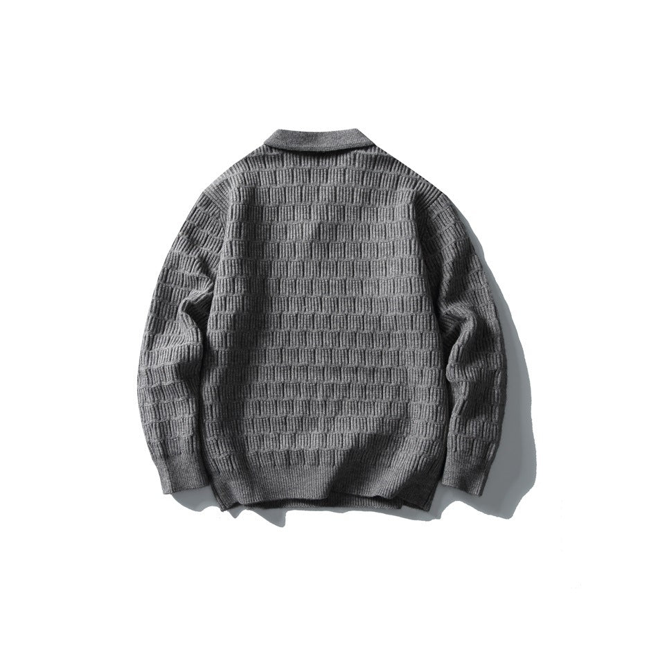 Back view of a charcoal gray textured knit sweater with a fold-over collar and ribbed cuffs and hem, laid flat.