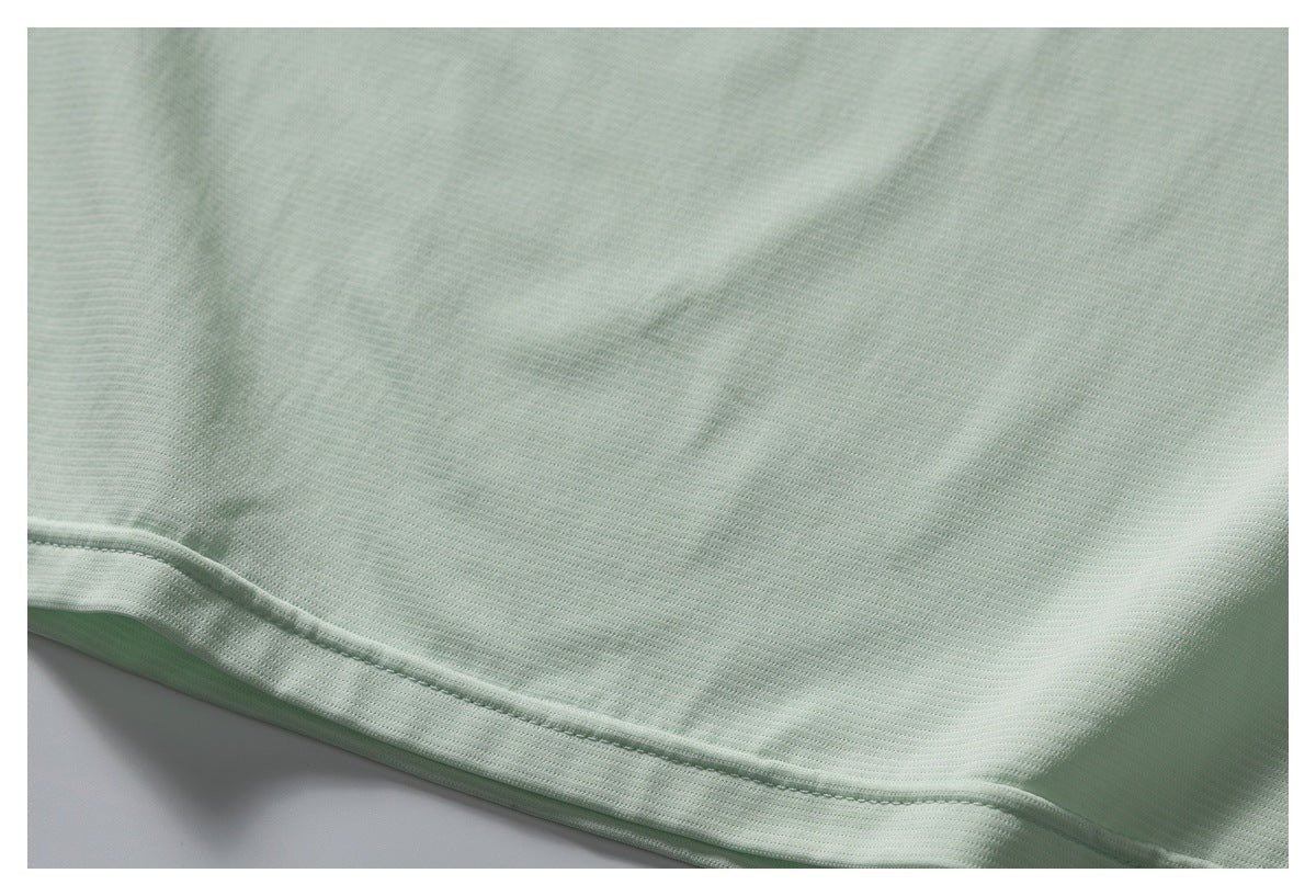 Close-up of the pale mint shirt's textured fabric and stitched bottom hem.