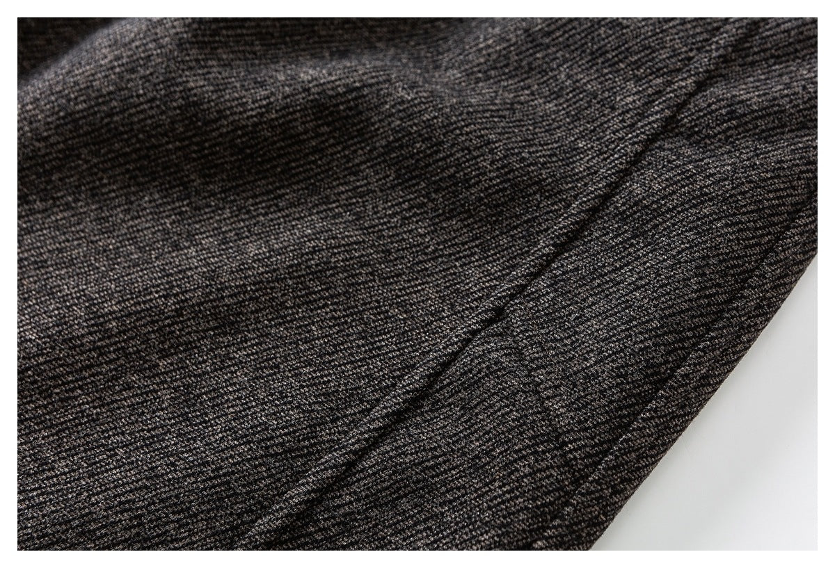 Close-up of the fine marled texture and seam on charcoal gray pants.