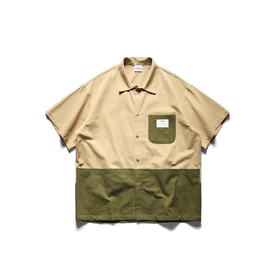 Short-sleeve button-front shirt with a khaki upper and olive green lower panel and green chest pocket, flat lay