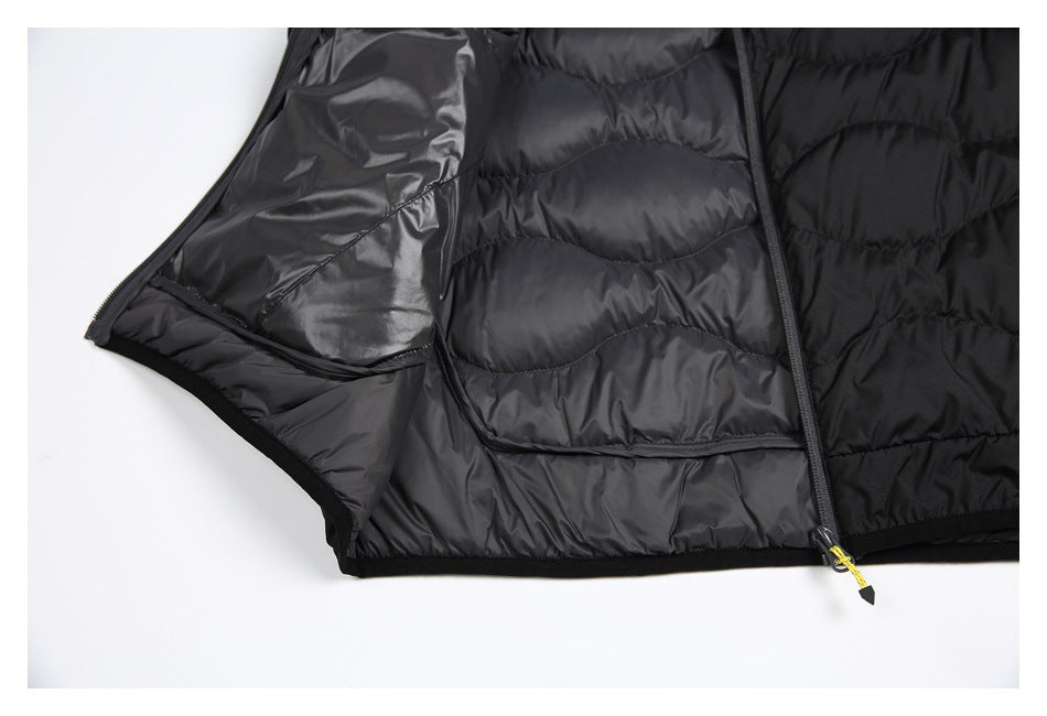 Close-up of an open black quilted jacket showing its lining, interior pocket, and front zipper.