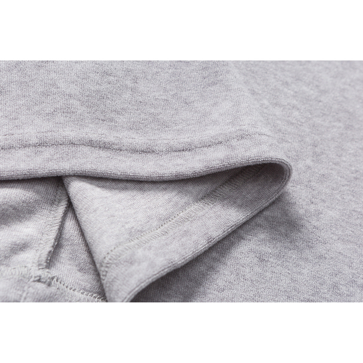 Close-up of a folded, stitched edge on heather-gray knit fabric.