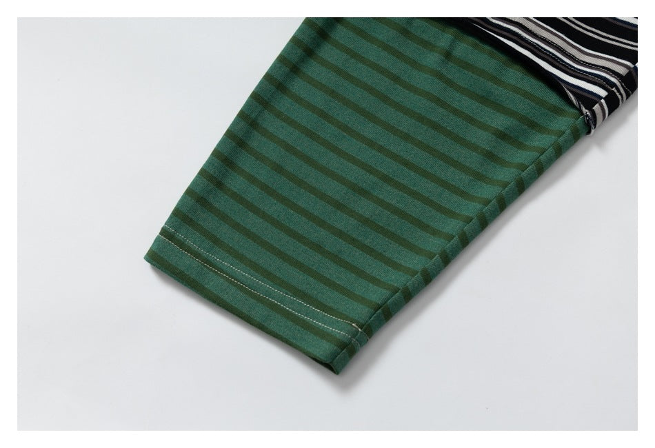 Close-up of a green striped garment sleeve and hem, with a black-and-white striped section visible behind it.