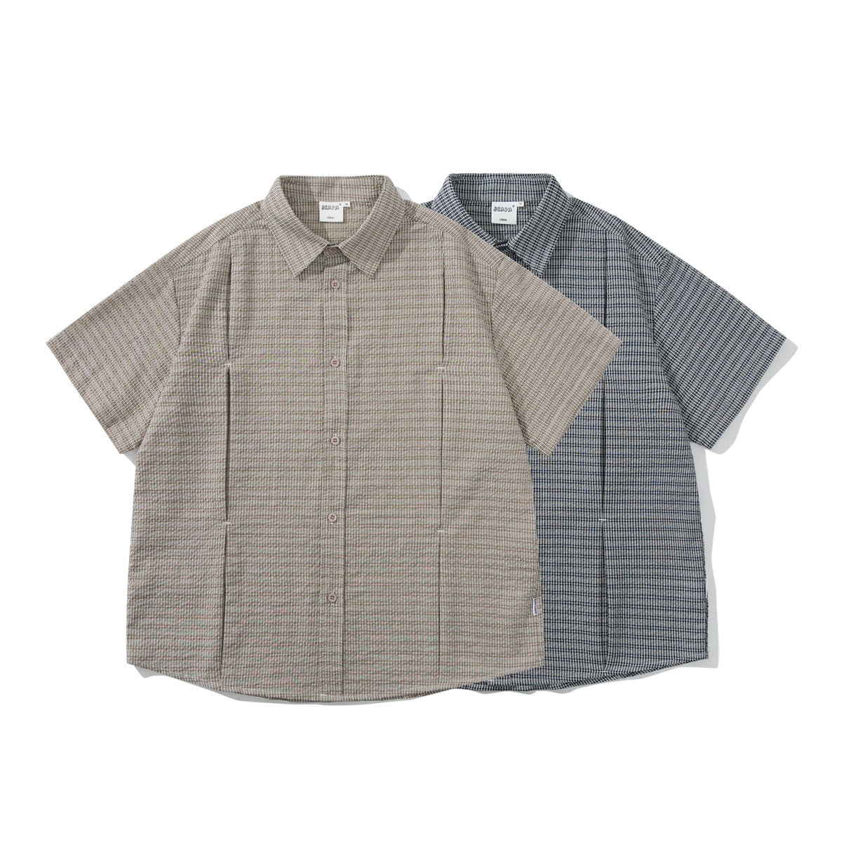 Two short-sleeve button-up shirts shown from the front: beige striped and dark blue striped.