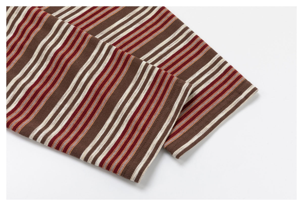 Close-up of a brown garment with cream, burgundy, and thin orange stripes and a stitched hem.
