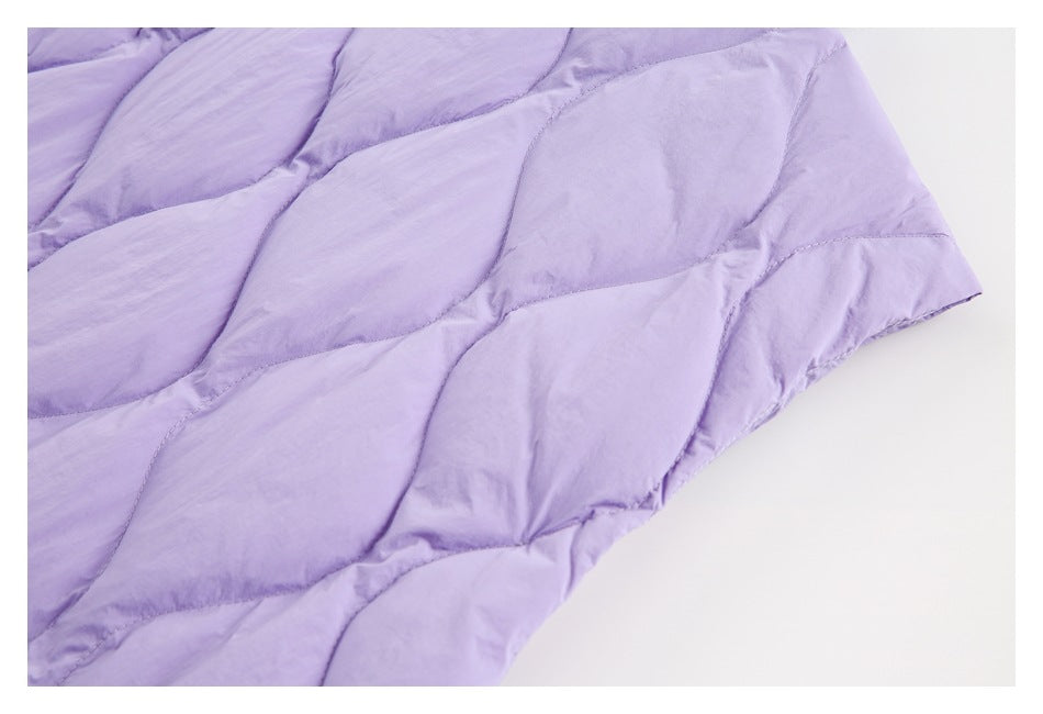 Close-up of lavender fabric with curved, leaf-like quilted stitching.