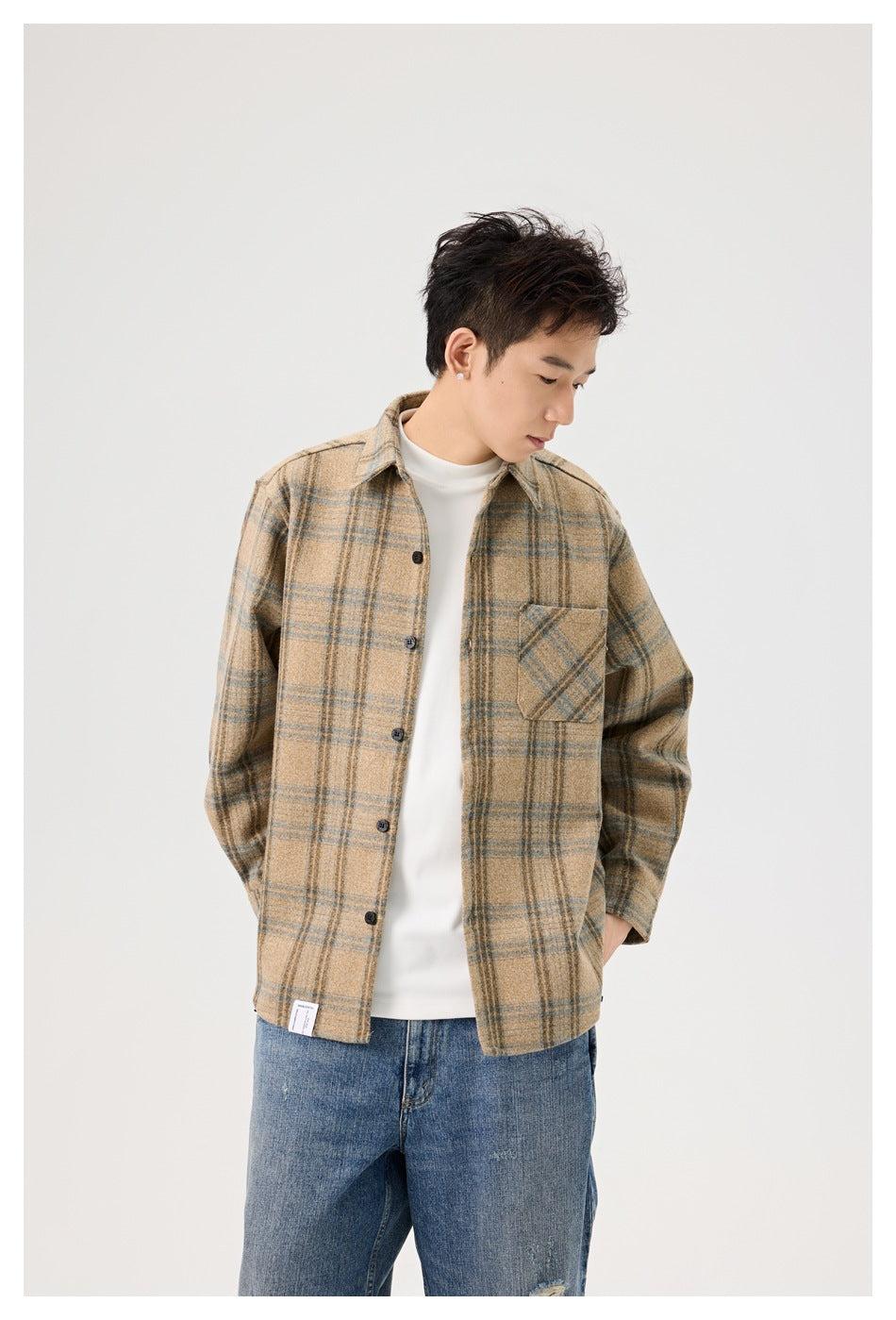 Model in a light khaki plaid long-sleeve shirt over a white tee, showing the chest pocket and buttons