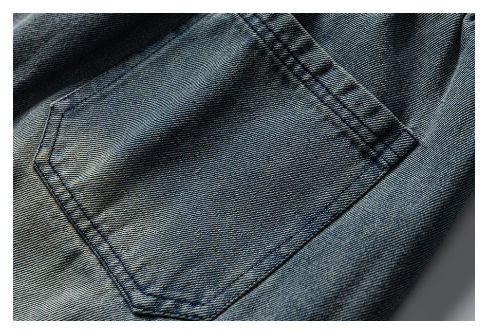 Close-up of a rectangular stitched patch pocket on blue denim.