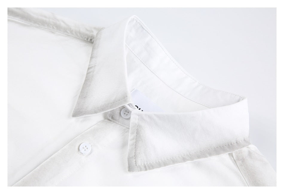 Close-up of the white shirt’s pointed collar and upper button placket.
