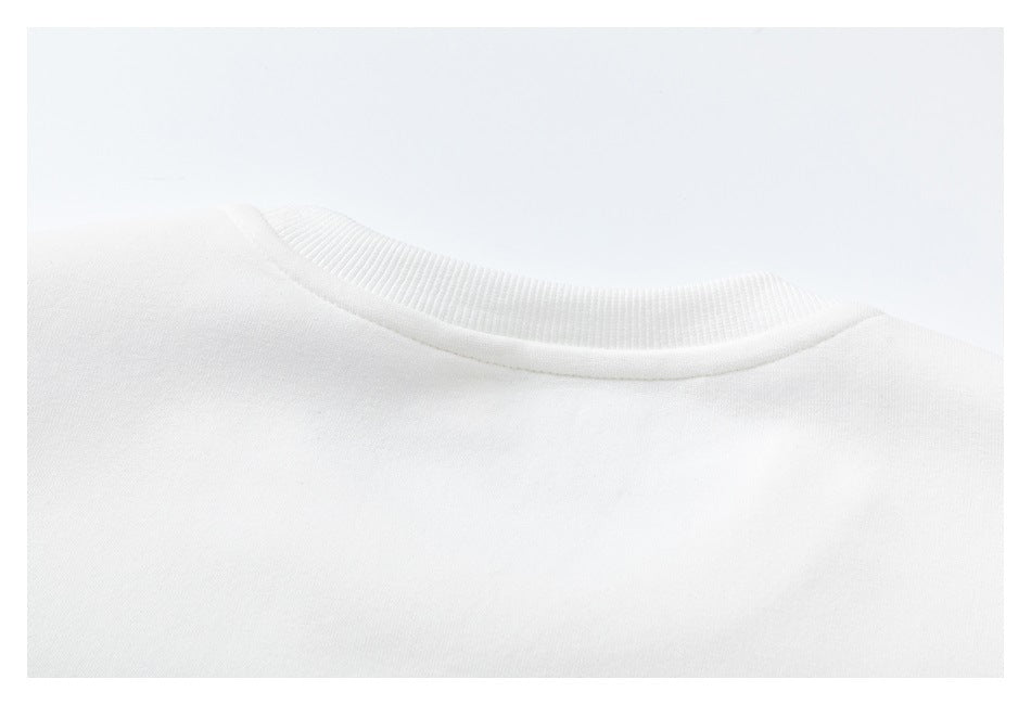Close-up of a white garment's round ribbed neckline and shoulder area.