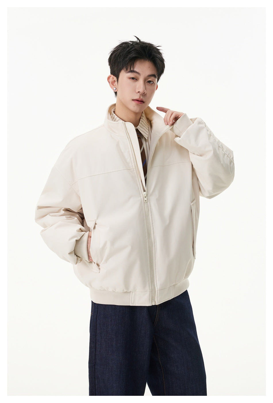 Model wearing an oversized cream zip-front jacket with a stand collar and ribbed hem, paired with dark jeans.