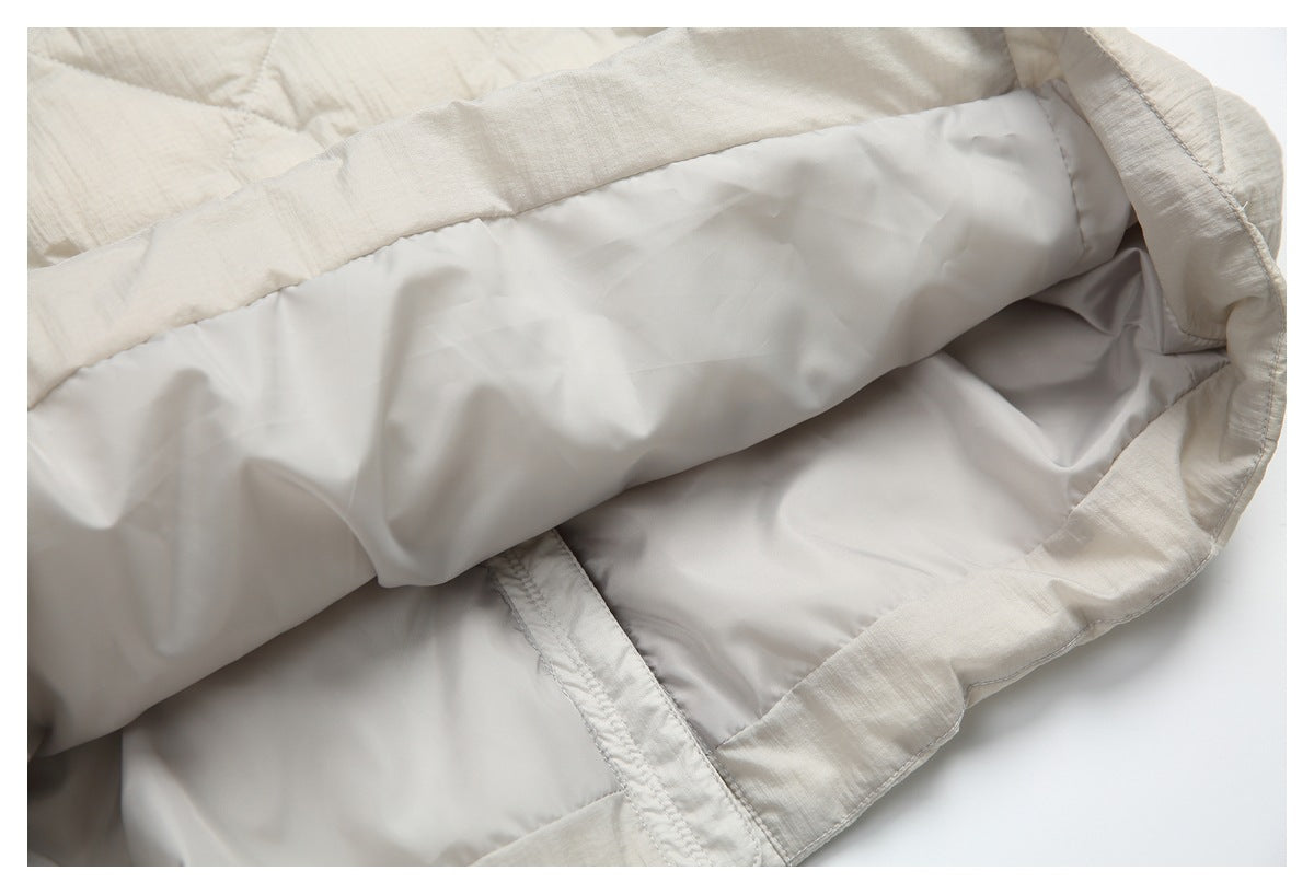 Close-up of a light beige garment interior, showing smooth pale lining, stitched seams and the finished edge.
