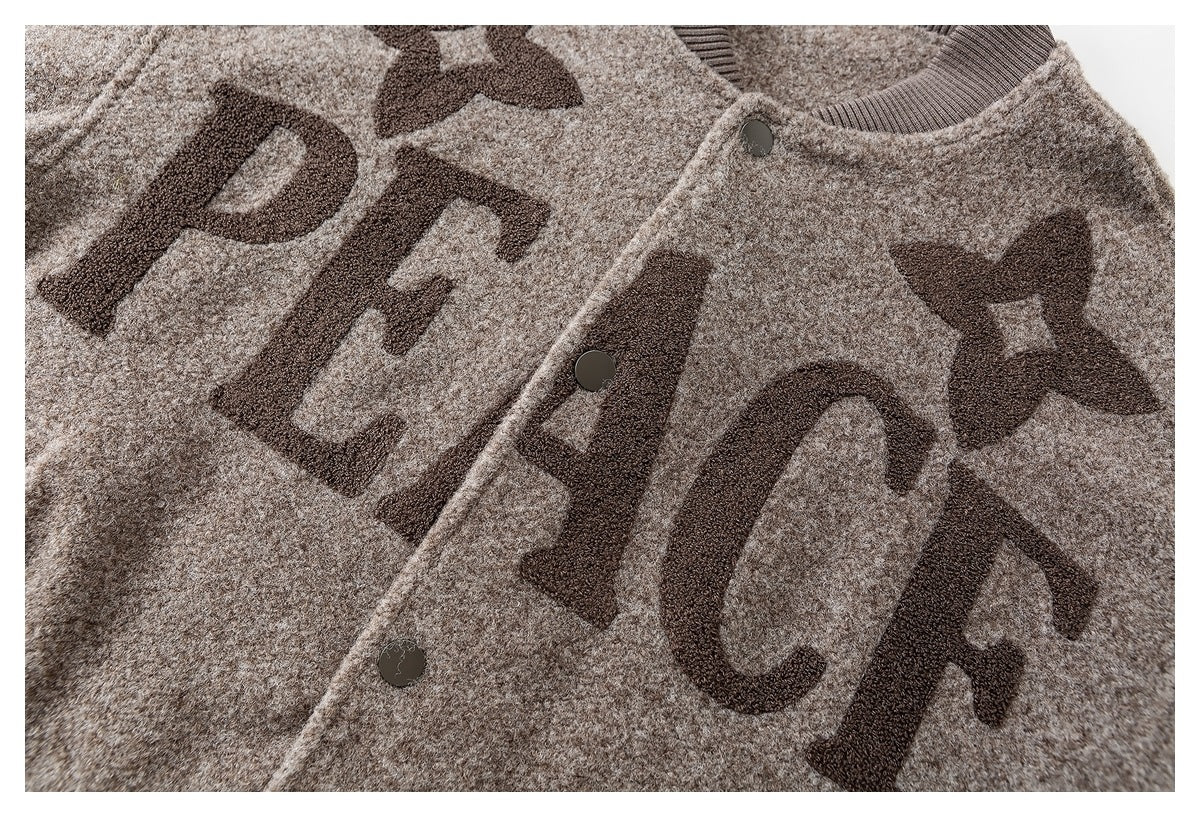 Close-up of the taupe jacket front with dark PEACE lettering, star motifs and snap buttons.