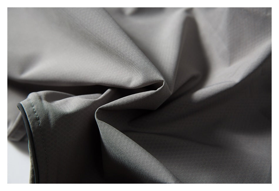 Close-up of gray garment fabric folds and a stitched edge.
