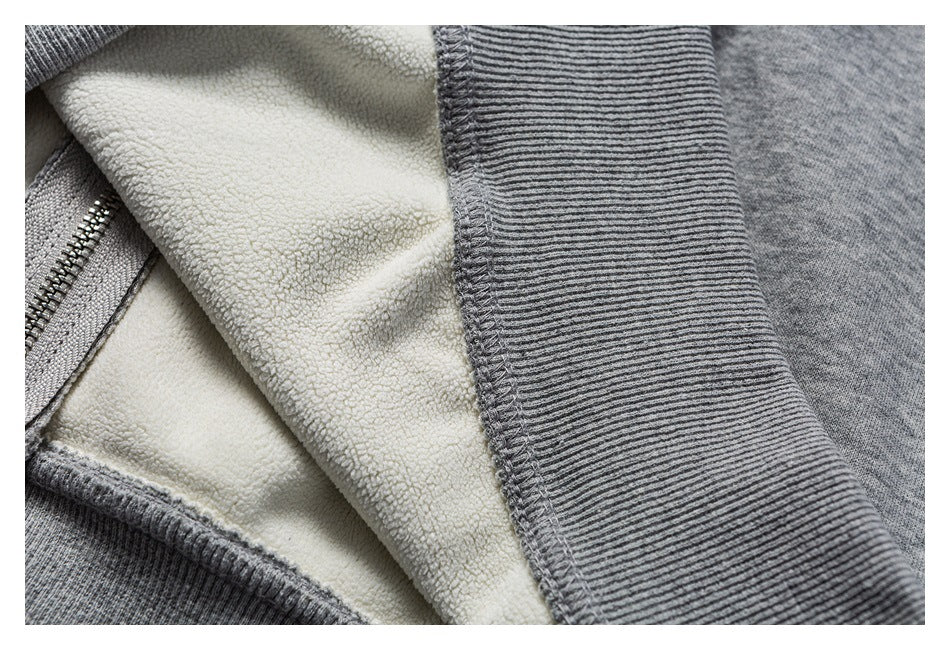 Close-up of a gray zippered garment showing cream textured lining and a ribbed gray edge.